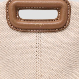 Maje bag in natural canvas with tan leather top handle and contrast stitching detail, close-up shot.