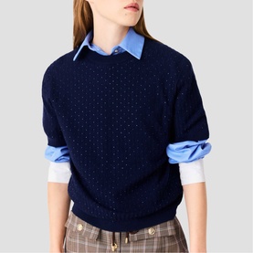Model wearing Maje navy blue knit sweater with embellished dot detail, styled with light blue shirt and plaid trousers