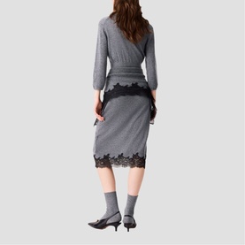 Model wearing Maje Womens French Dress in red, featuring black lace hem trim, styled with grey socks and black kitten heels, rear view.