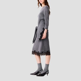Model wearing Maje Womens French Dress in red with black lace hem trim, styled with black pointed kitten heel boots and grey socks.
