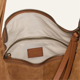 Bash brown suede bag interior showing zip pocket, cream lining, and branded leather patch, with gold-tone zipper detail.