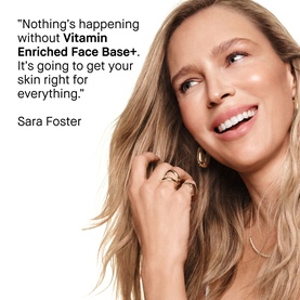 Model with Bobbi Brown Vitamin Enriched Face Base+ moisturiser. Smiling blonde model touches face, with quote endorsement from Sara Foster.