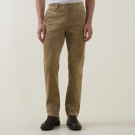 Model wearing Gant light taupe cotton chino trousers with a straight leg fit, styled with brown leather hiking boots.