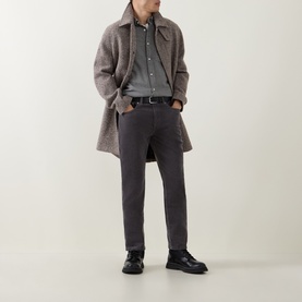 Model wearing Gant Dusky Anthracite Cord Jeans, styled with a taupe wool overcoat, grey shirt, and black leather shoes.