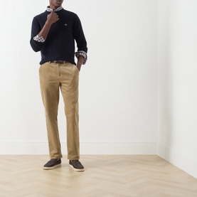 Model wearing Gant navy wool crew neck jumper, styled with tan chinos, printed shirt, and dark brown loafers.