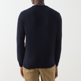 Model wearing Gant navy wool crew neck jumper, back view, styled with beige trousers.