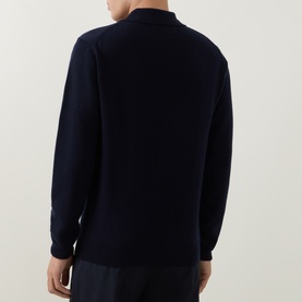 Model wearing Gant Shield Logo Fine-Knit Polo Sweater in navy, rear view, showing fine-knit wool construction and ribbed trims, styled with dark