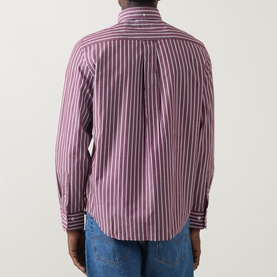 Model wearing Gant Reg Shirt in deep grape wine, rear view showing vertical stripes, centre pleat, and button cuffs, styled with blue jeans.