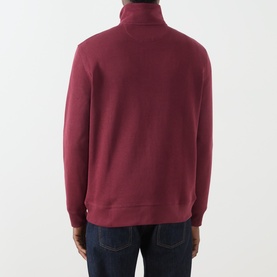 Model wearing Gant Deep Grape Wine cotton sweatshirt, back view showing turtleneck collar and half-zip, styled with dark jeans.