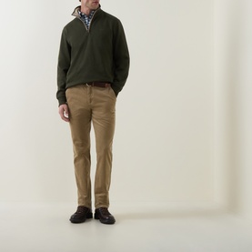 Model wearing Gant dark moss green cotton half-zip sweatshirt, styled with tan chinos, check shirt, and dark brown shoes.