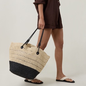 Model carrying InWear Pawl Shopper Tote Bag in Nature, cream and black crochet with colour-block base and black carry handles.
