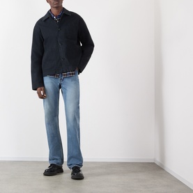 Model wearing JW Anderson black cotton casual jacket, styled with light wash jeans and black loafers.