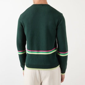 Model wearing JW Anderson Sheep Stripe Sweater in Dark Fir, back view showing pink and green stripe detail at hem and cuffs, styled with cream
