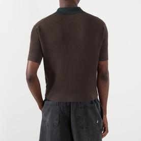 Model wearing JW Anderson Military Green cotton-cashmere knit polo, rear view, styled with grey cargo shorts.
