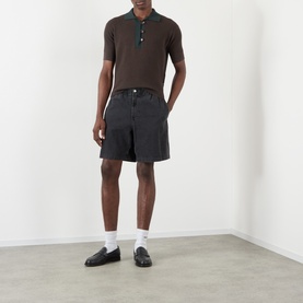 Model wearing JW Anderson Military Green cotton-cashmere polo with dark denim shorts, white socks and black loafers