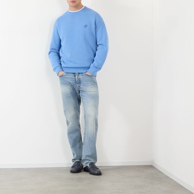 Model wearing JW Anderson Ribbon Anchor Logo Sweatshirt in washed blue with light wash jeans and black loafers.