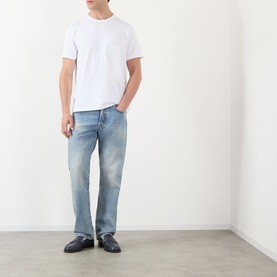 Model wearing JW Anderson Anchor Logo T-Shirt in white with light wash straight-leg jeans and black loafers.