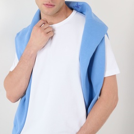 Model wearing JW Anderson Anchor Logo T-Shirt in white, round neck, short sleeves, styled with a blue scarf draped over shoulders.