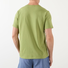 Model wearing JW Anderson Circular Logo T-Shirt in leaf green, rear view, round neck, short sleeves, styled with blue shorts.