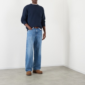 Model wearing JW Anderson navy cotton sweatshirt with light blue wide-leg jeans, brown belt, and tan suede loafers