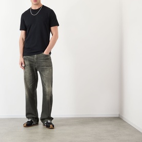 Model wearing JW Anderson Anchor Logo T-Shirt in black with dark wash straight-leg jeans and black trainers.