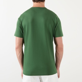 Model wearing JW Anderson Scattered Logo T-Shirt in green, back view, round neck, short sleeves, straight hemline, 100% cotton.