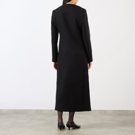 Model wearing Loulou Studio black wool coat, rear view, midi length, long sleeves, styled with black heels and sheer tights