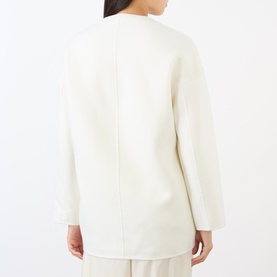 Model wearing Loulou Studio ivory wool-cashmere coat, shown from rear, featuring clean seam detailing and relaxed silhouette.