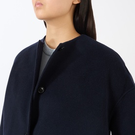 Model wearing Loulou Studio navy melange wool cashmere coat, collarless design with single button fastening, styled with grey knit