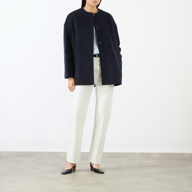 Model wearing Loulou Studio Navy Melange wool cashmere coat, styled with white trousers and black flat shoes.