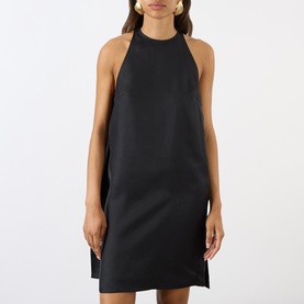 Model wearing Loulou Studio black silk halterneck mini dress with side splits, styled with gold hoop earrings