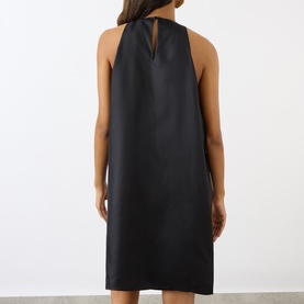 Model wearing Loulou Studio black silk dress, back view, halterneck with keyhole detail, sleeveless A-line silhouette