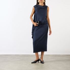Model wearing Loulou Studio navy silk dress with draped twist neckline, sleeveless silhouette and midi length, styled with black heels
