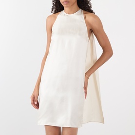 Model wearing Loulou Studio ivory silk mini dress with halterneck silhouette and open back, styled loose and sleeveless.