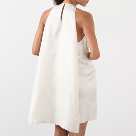 Model wearing Loulou Studio ivory silk dress, rear view, halterneck, A-line silhouette, sleeveless style.