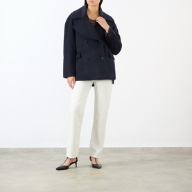 Model wearing Loulou Studio navy melange wool cashmere jacket, double-breasted, styled with white trousers and black heels.