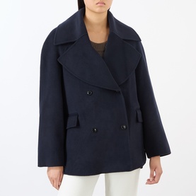 Model wearing Loulou Studio navy melange wool-cashmere double-breasted jacket with wide lapels and flap pockets, styled with white trousers.