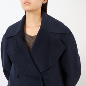 Model wearing Loulou Studio navy melange wool cashmere jacket, styled with a brown knit top, showing wide lapels and double-breasted front.