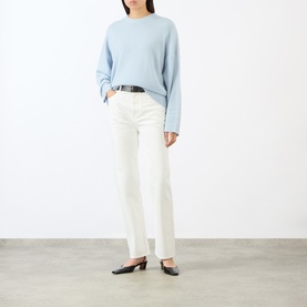 Model wearing Loulou Studio Ivory Jeans with black belt, styled with a pale blue knit sweater and black mules.