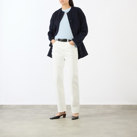 Model wearing Loulou Studio Ivory Jeans with navy longline jacket, light blue top and black heeled mules