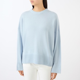 Model wearing Loulou Studio light blue cashmere crew-neck sweater with ribbed cuffs and hem, styled with white trousers