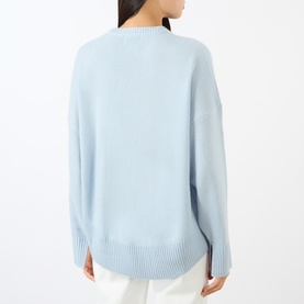 Model wearing Loulou Studio light blue cashmere knit sweater, back view, relaxed fit with ribbed hem and cuffs.