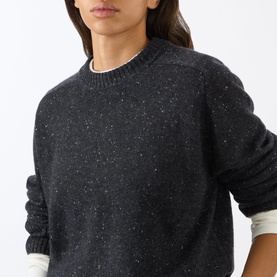 Model wearing Loulou Studio cashmere knit in Peppered Anthracite, featuring a crew neck and speckled texture