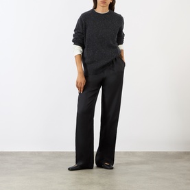 Model wearing Loulou Studio peppered anthracite cashmere knit, styled with wide-leg dark trousers and black flat shoes.