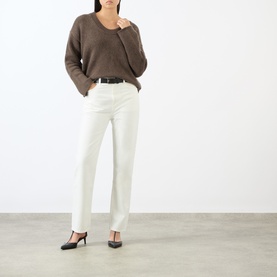 Model wearing Loulou Studio brown cashmere knit sweater with wide sleeves, styled with white straight-leg trousers and black heels.
