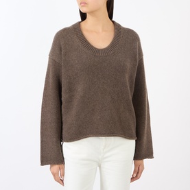 Model wearing Loulou Studio brown cashmere knit jumper with V-neck and wide sleeves, styled with white jeans.
