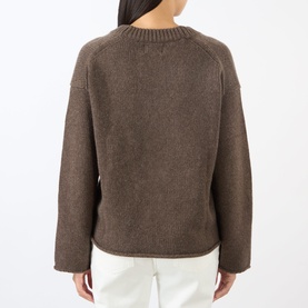 Model wearing Loulou Studio brown cashmere knit sweater, back view, with white trousers. Relaxed fit with raglan sleeves.