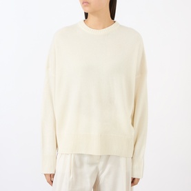 Model wearing Loulou Studio ivory cashmere crew neck jumper with ribbed cuffs and hem, styled with cream wide-leg trousers