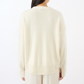 Model wearing Loulou Studio ivory cashmere knit sweater, back view, ribbed cuffs and hem, relaxed fit with side vents.
