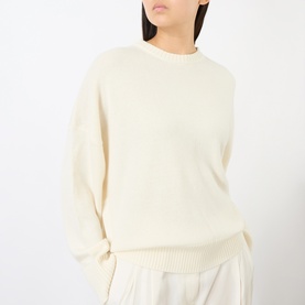 Model wearing Loulou Studio ivory cashmere crew neck sweater with relaxed fit and ribbed cuffs, styled with wide-leg trousers.